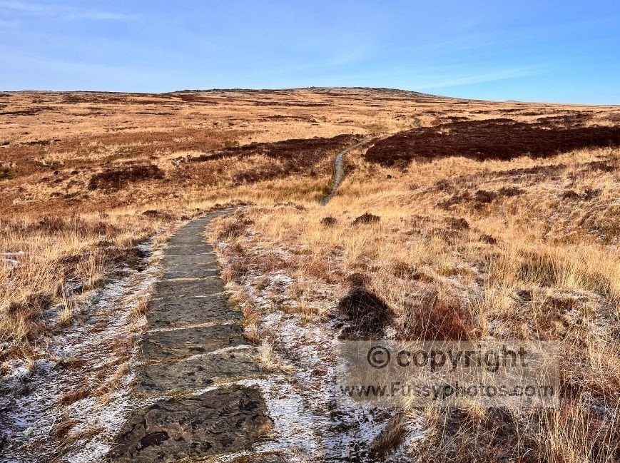Paving stone path climbing towards Blackstone Edge on the Pennine Way near the M62