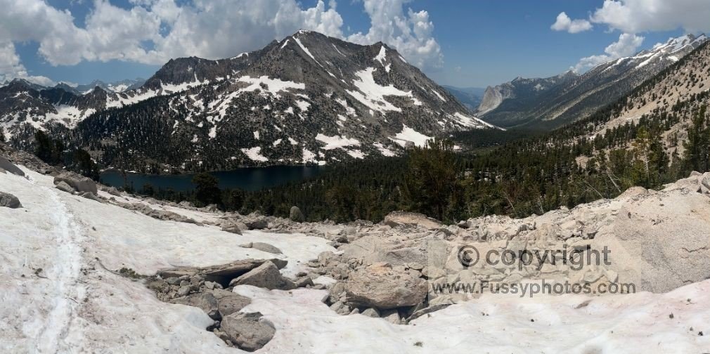 Heading north on the snowy JMT toward Glen Pass, with Charlotte Lake visible below to the west.