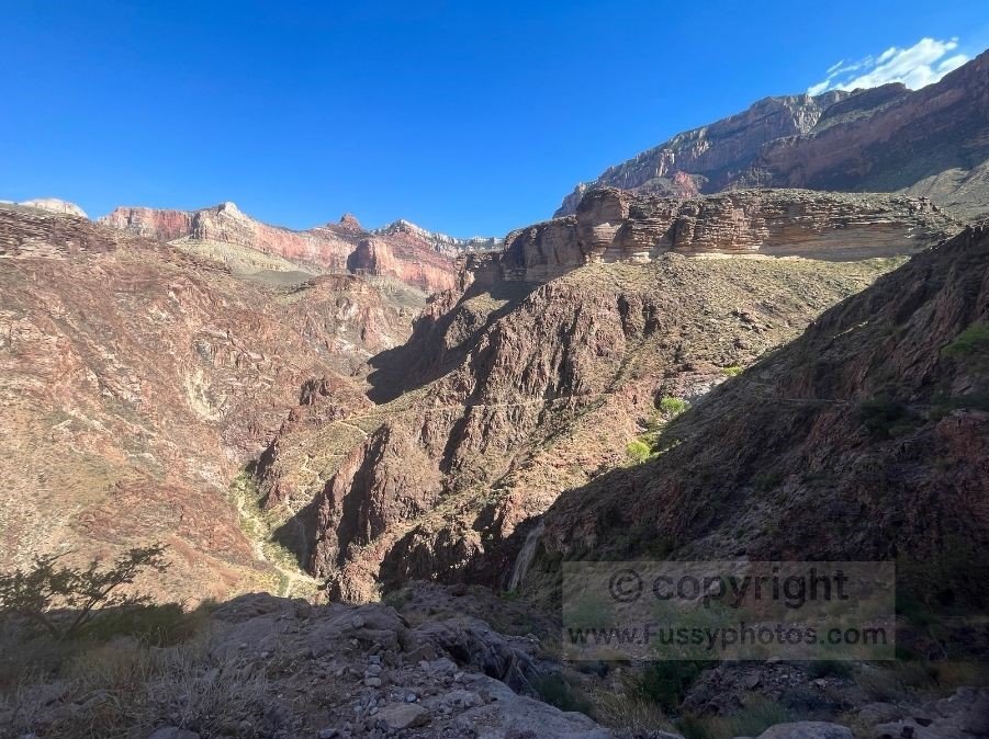 A view of the Devil’s Corkscrew switchbacks on the Bright Angel Trail, showing steep, sun‑exposed zigzags carved into the canyon walls in late‑afternoon light.