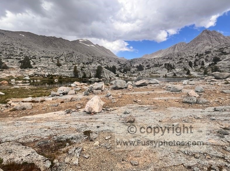 Eastward view across Darwin Bench, showing a flat, boulder‑strewn granite plateau high above the treeline on the approach to Lamarck Col.