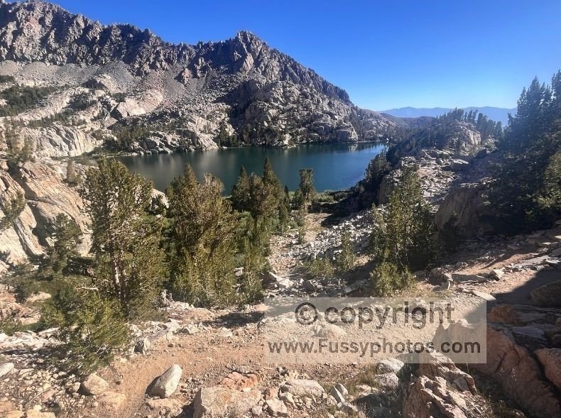 Upper Lamarck Lake seen from the base of the steep Lamarck Col switchbacks, where the descent eases and the valley opens below.
