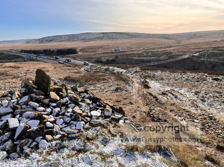 South‑facing view from the M62 footbridge on the Pennine Way with moorland beyond the motorway