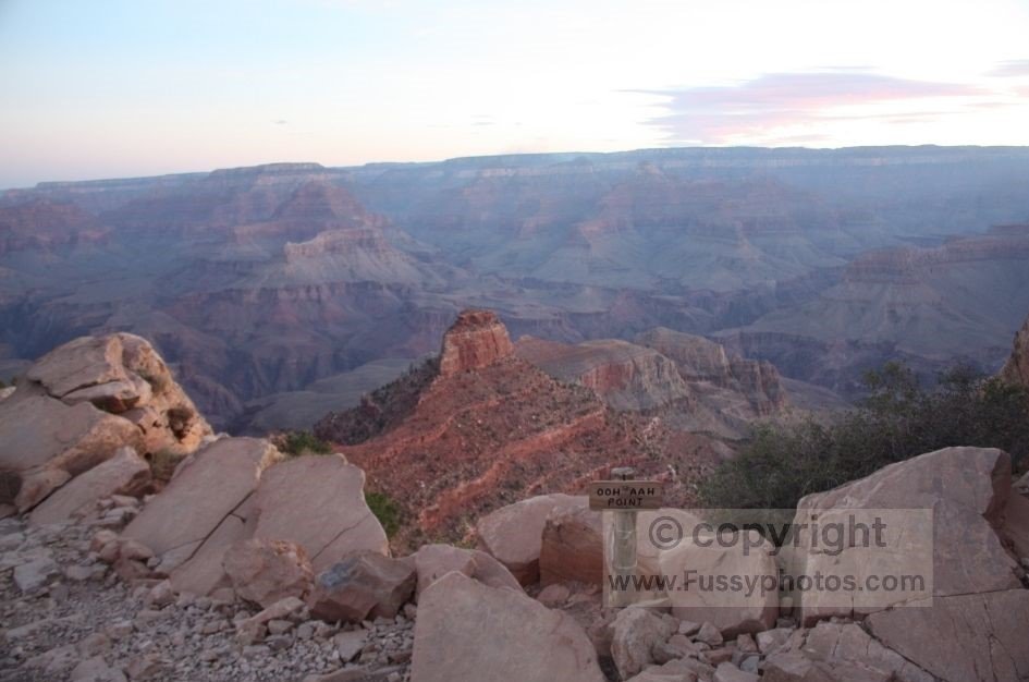 A morning view from Ooh Aah Point on the South Kaibab Trail, showing the wide canyon landscape and layered cliffs under early sunlight.