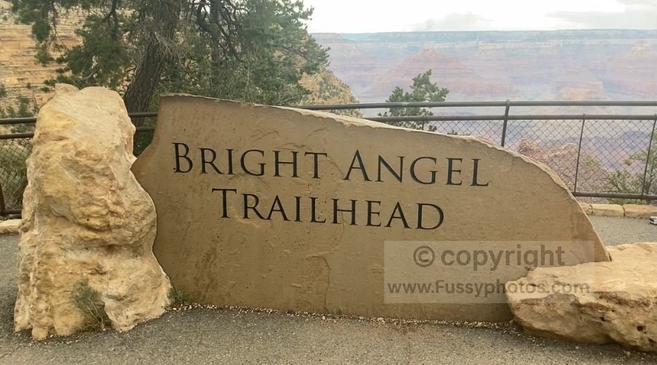 The Bright Angel Trailhead on the South Rim, showing the start of the trail beside the canyon edge with clear views into the upper layers of the Grand Canyon.