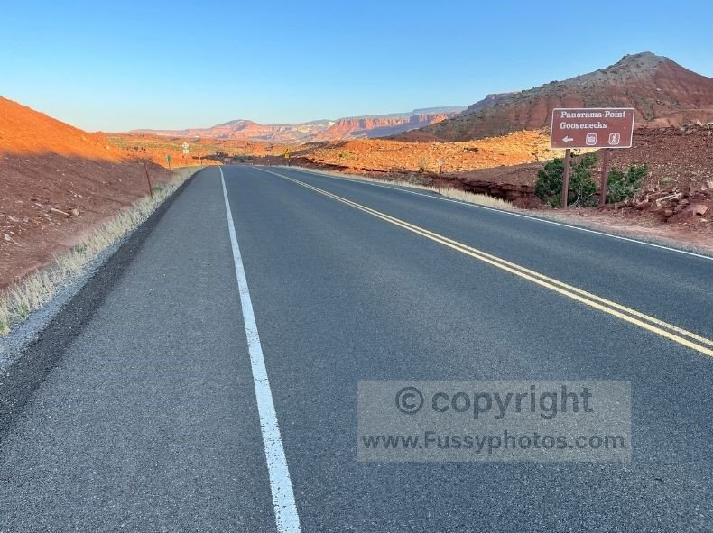 Road sign pointing toward Goosenecks and Panorama Point in Capitol Reef, set against red‑rock cliffs and highlighting two easy, family‑friendly viewpoints with big canyon scenery and minimal walking.