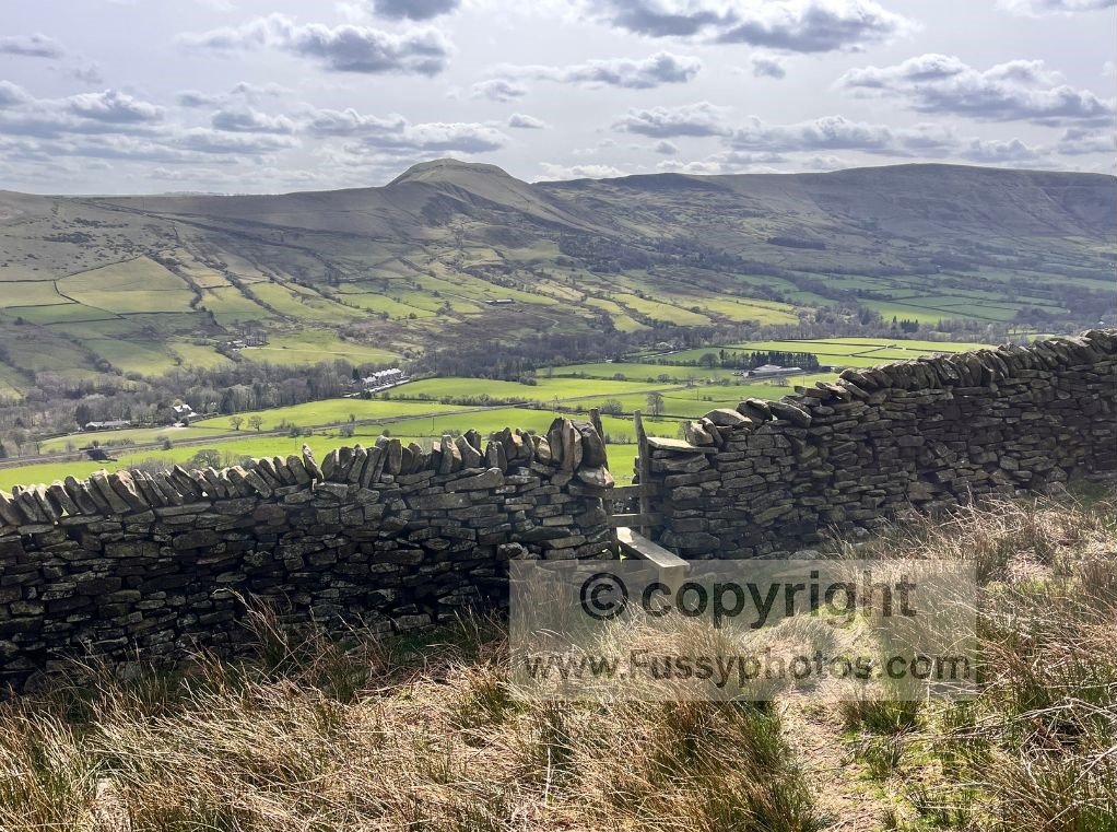 View south from a stile on the steep valley ascent, overlooking Edale Valley and Mam Tor in the distance.