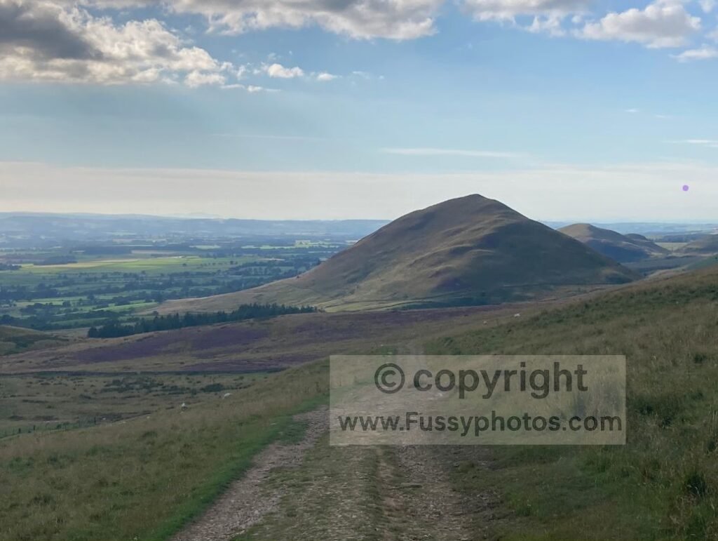 View down the easy descent into Dufton, with broad hills and open moorland ahead.