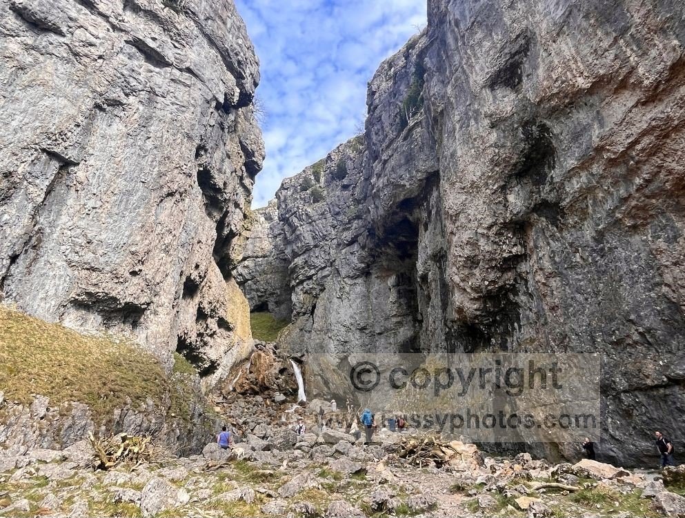 Waterfall at the end of Gordale Scar, hidden around a bend in the gorge with steep limestone walls rising on both sides.