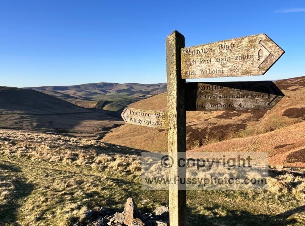 Southward view of the trail junction and sign where the high and low routes reconverge on the Pennine Way, taken over a mile beyond the earlier ascent.