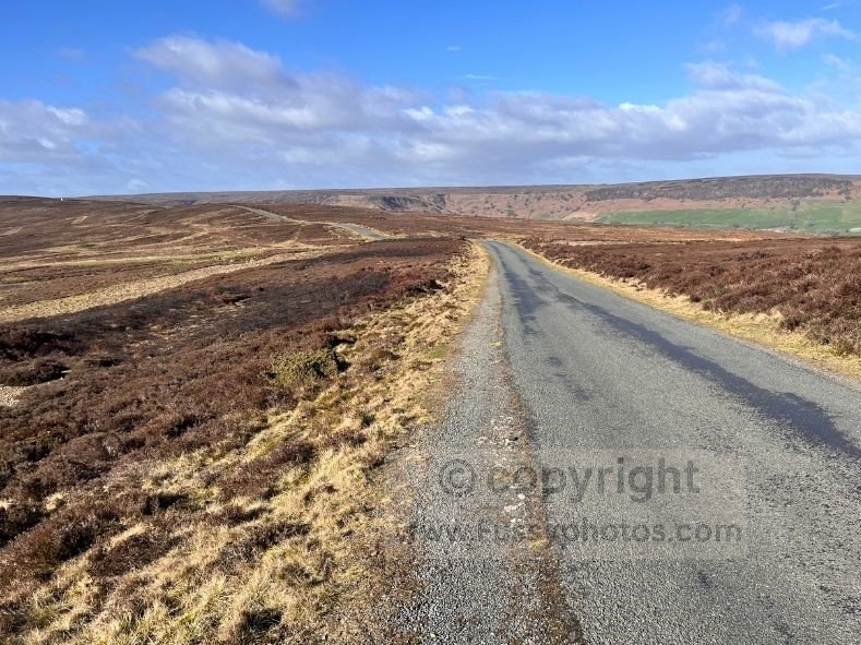 Windswept road section across Glaisdale Moor on the Coast to Coast, with Great Fryup Dale just visible to the right along the exposed ridge.