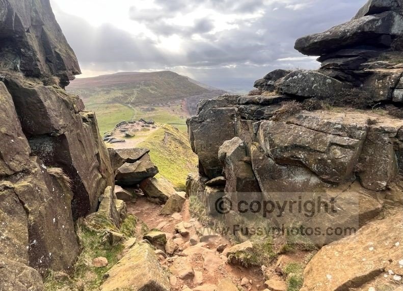 Path dissecting the rocky Wainstones on the Coast to Coast, highlighting the hands‑on scramble section across the boulders.