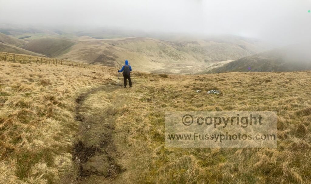 Steep descent from Auchope Cairn, just below the cloud layer, with northward views towards The Schil, whose summit is hidden in mist.