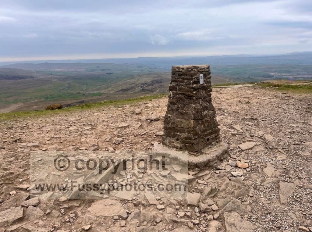 Summit view looking northeast from Pen‑y‑Ghent, showing the flat plateau and open moorland beyond.
