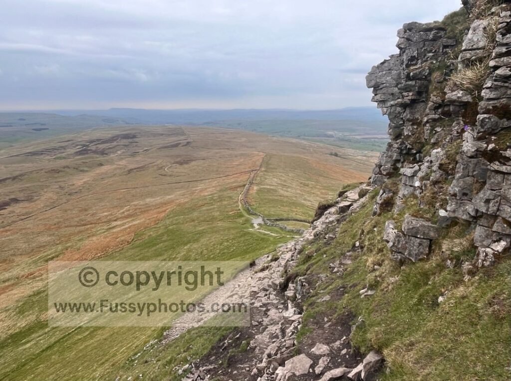 Southeast view from the ascent of Pen‑y‑Ghent, with a faint outline of the Pennine Way visible on the distant slope.