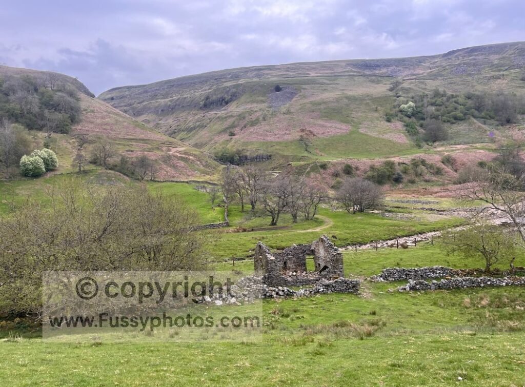 View across Swinner Gill from the lower path on Wainwright’s Pennine Journey, showing the moorland slopes rising above the valley.