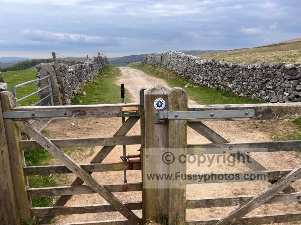 National Trail bridleway arrow with white acorn on a gate on the Pennine Way descent from Pen‑y‑ghent to Horton‑in‑Ribblesdale.