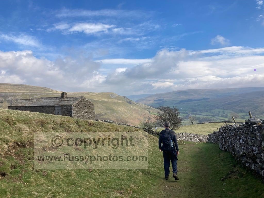 View looking east from the high path above the farm buildings near Thwaite, showing upper Swaledale before the River Swale comes into view.