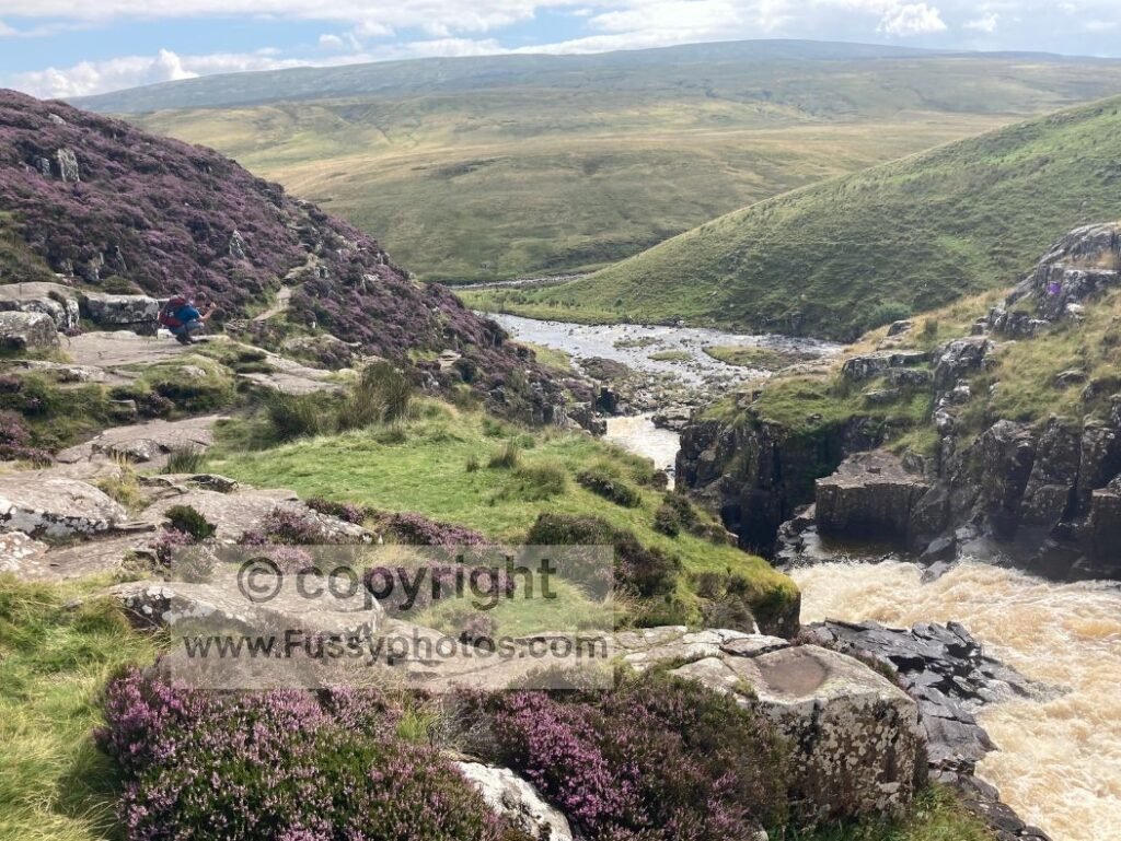 Downward perspective over Cauldron Snout, showing heather‑lined banks and the surrounding moorland.