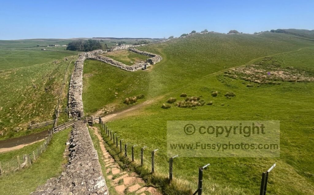 Photo of Cawfields Milecastle viewed from the west, looking east along the Whin Sill with the stepped ascent onto the ridge visible ahead.