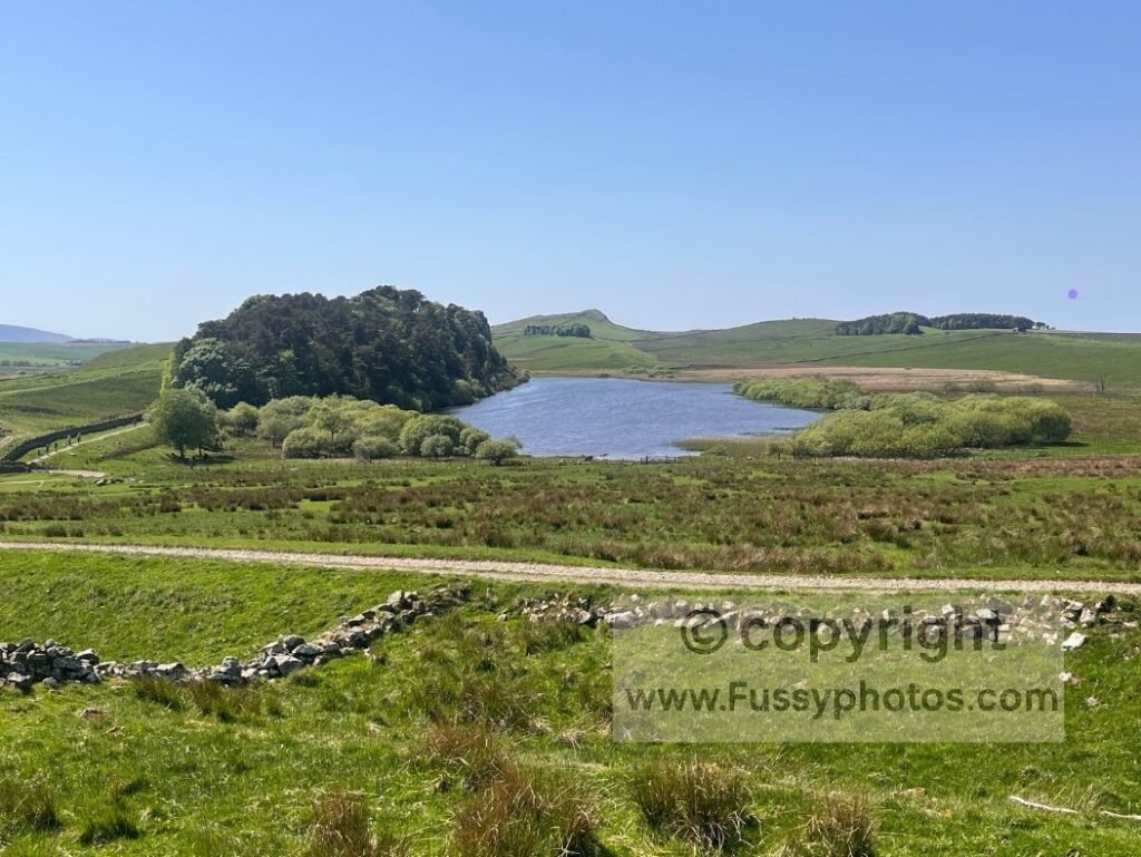 Elevated westward view towards Crag Lough, showing the Whinstone ridge rising above the lower terrain.