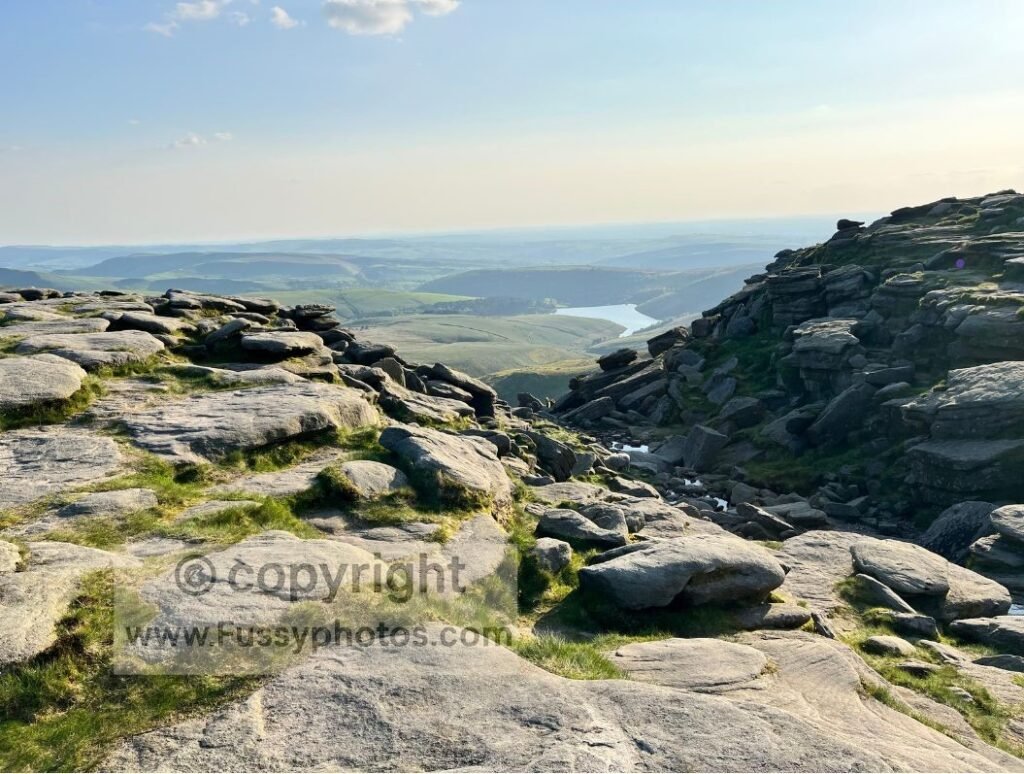 Water trickling towards the top of Kinder Downfall, with Kinder Reservoir in the background.