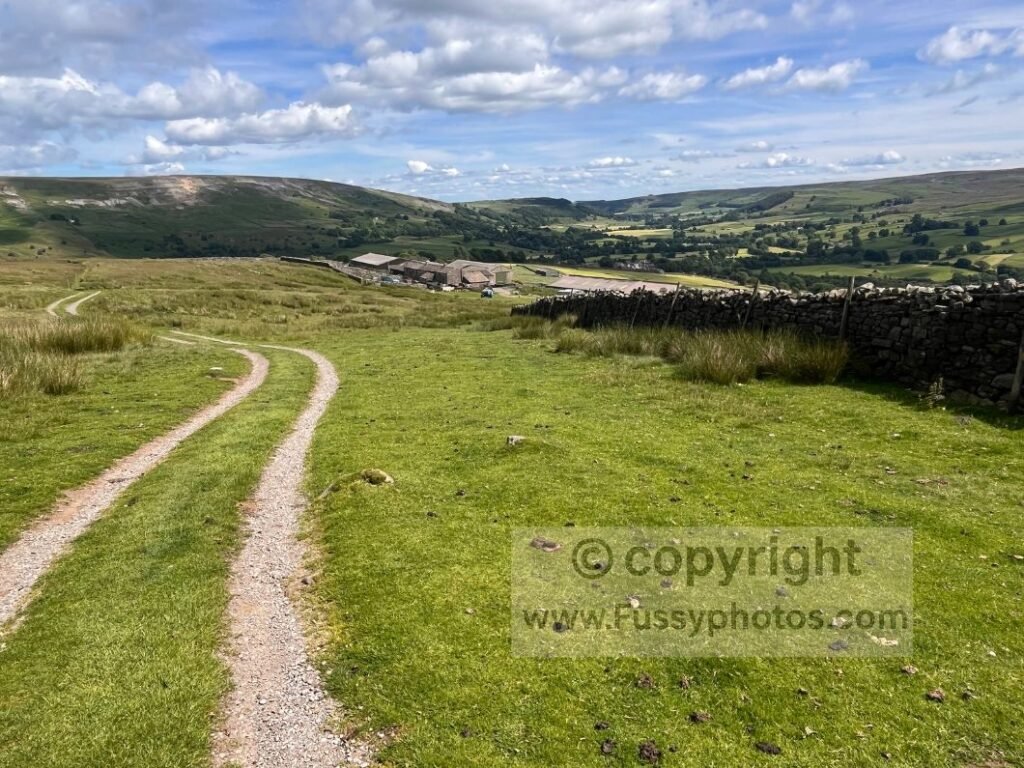 Reeth high‑route view — rising path on the Coast to Coast Path looking back towards Reeth.