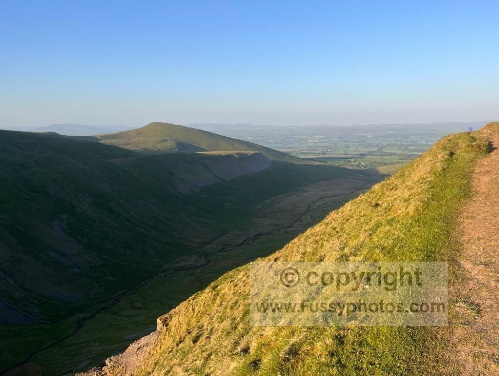 Trail above High Cup Gill alt — View of the path along the northern rim of High Cup Nick, looking into High Cup Gill which is largely in shadow.