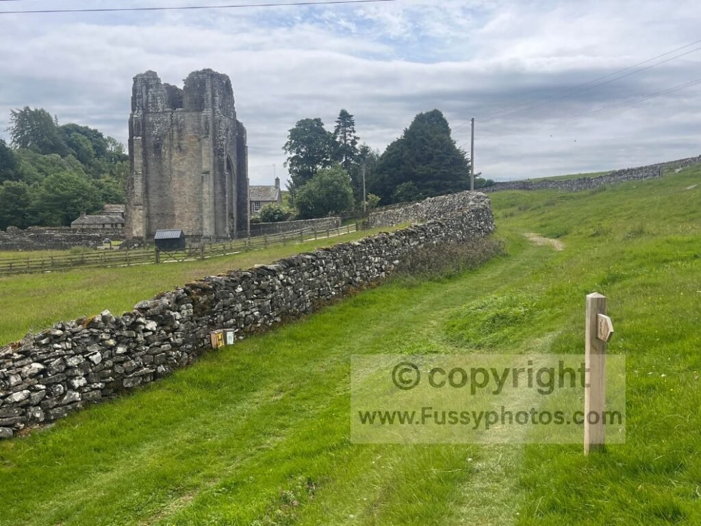 hoto of a Coast to Coast marker near Shap Abbey, taken where the trail passes close to the River Lowther and the 1200‑era Premonstratensian ruins.