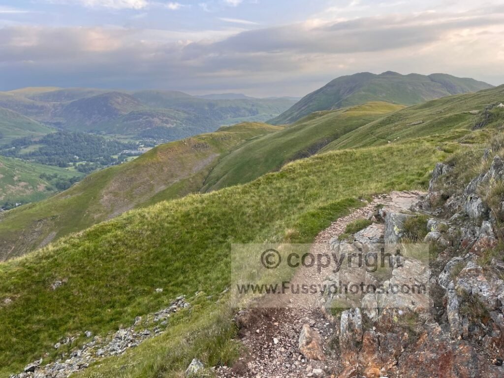 Rocky Coast to Coast descent towards Patterdale and the Ullswater valley with Helvellyn ahead.