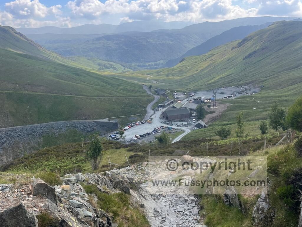 Eastward view from the rocky ascent above Honister Slate Mine, showing the stepped Coast to Coast path as it climbs towards Drum House.