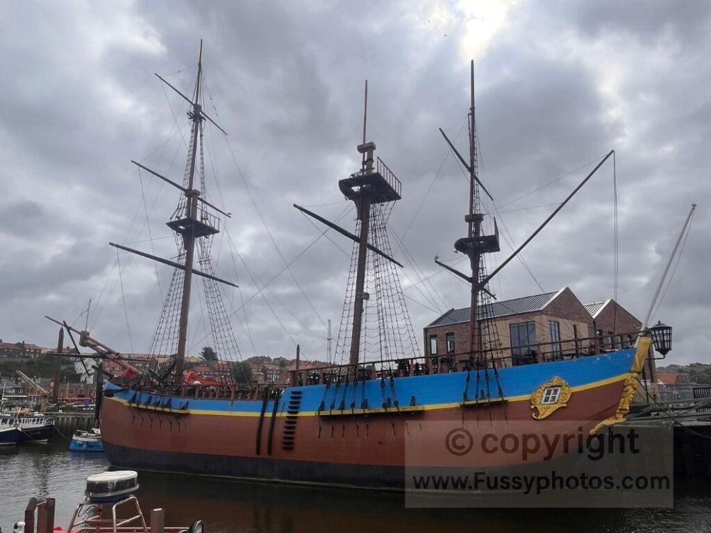 The Black Pearl ship in Whitby Harbour, photographed from the Cleveland Way as it follows the River Esk towards Whitby Bandstand.