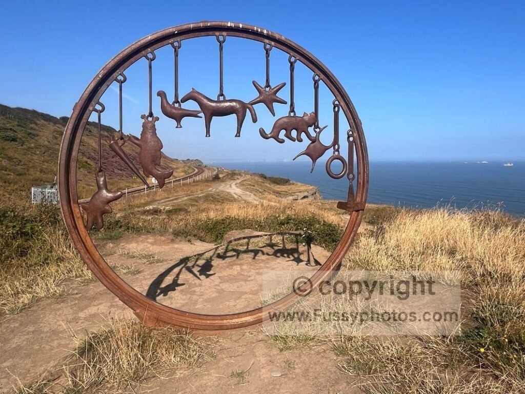 The Circle, a Charm Bracelet artwork on the Cleveland Way near Skinningrove, looking west with the old trainline visible behind the sculpture.