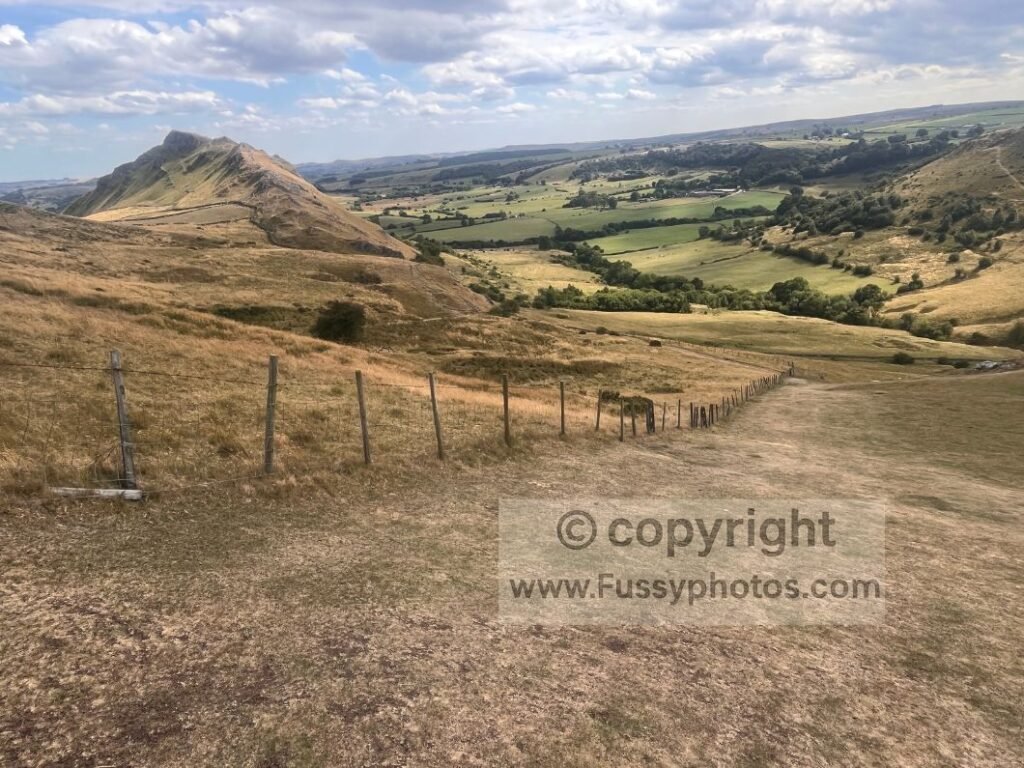 Northwest valley view of Chrome Hill showing its dragon’s‑back shape above dry‑stone walls.