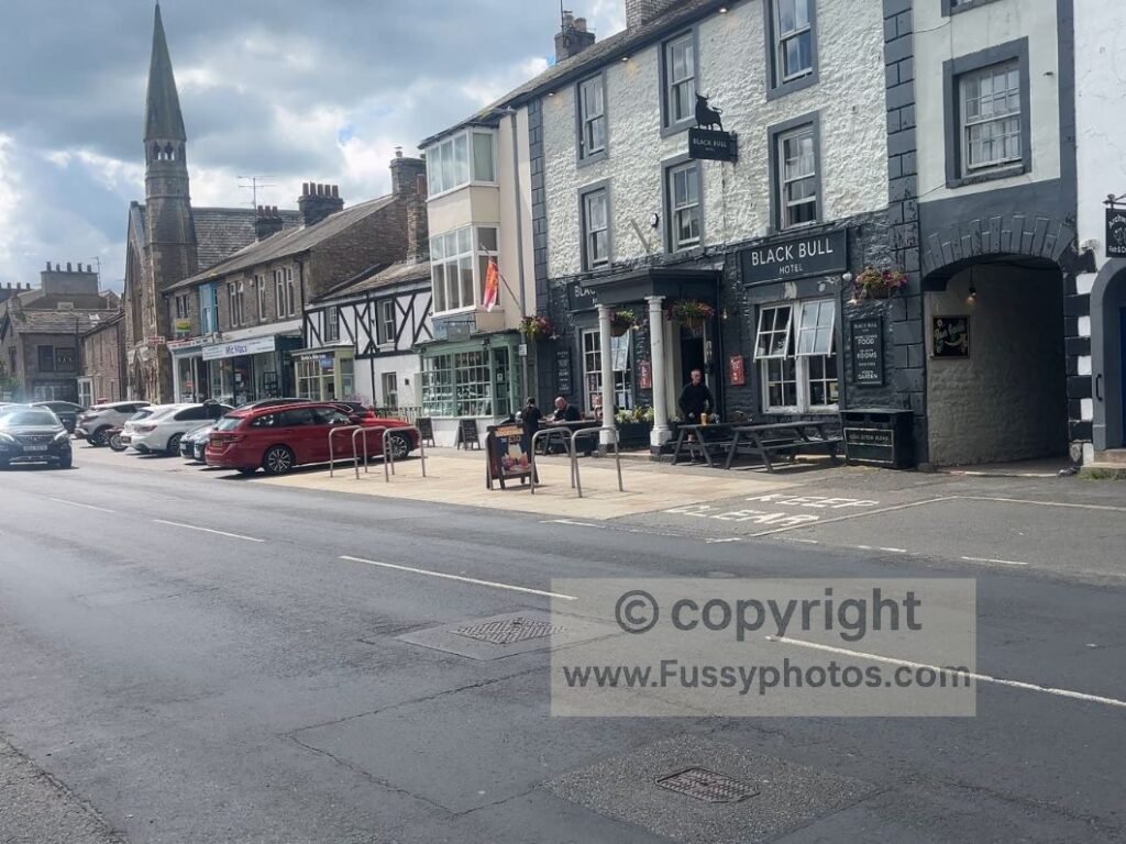 Kirkby Stephen town centre showing hotels, cafés, pubs and shops on the Coast to Coast route in Cumbria.