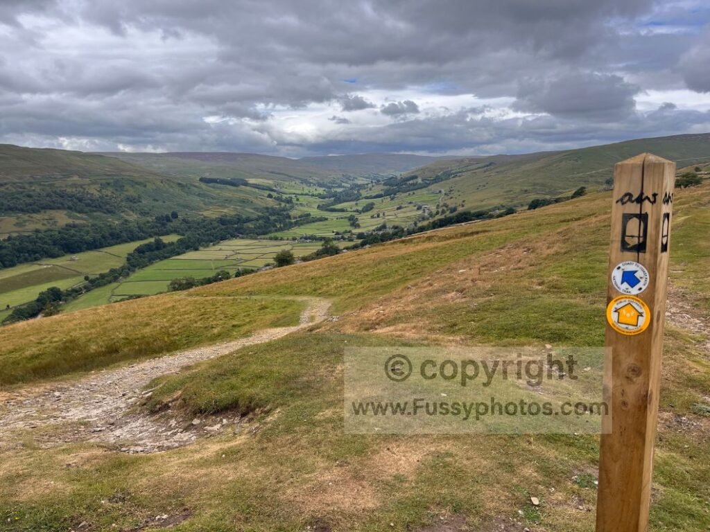 C2C trail sign Swaledale — Coast to Coast trail sign with Swaledale valley behind.

