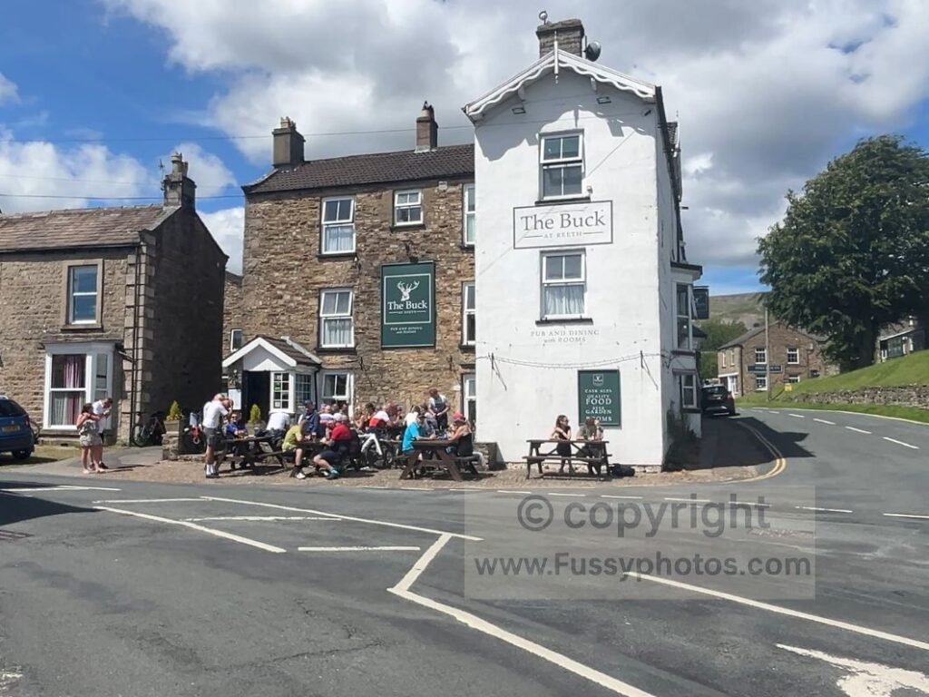 Busy pub in Reeth in Swaledale on the Coast to Coast, highlighting a popular social stop that influences group walking pace.
