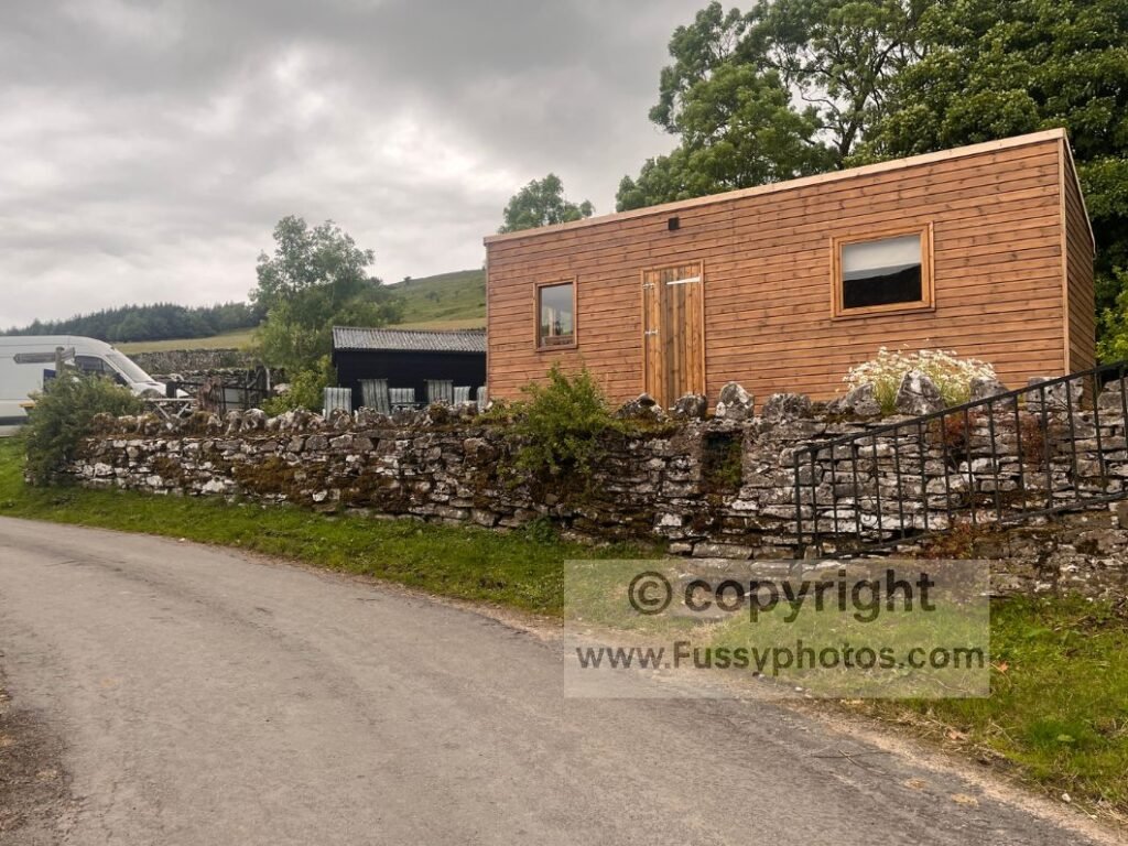 Exterior of Sunbiggin Farm with shower block and glamping shed in Cumbria on the Coast to Coast, highlighting the facilities available to campers.