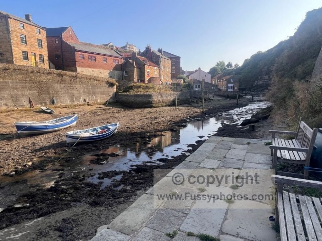 Benches beside Staithes Beck near the bridge, used as a rest stop before continuing on the Cleveland Way.